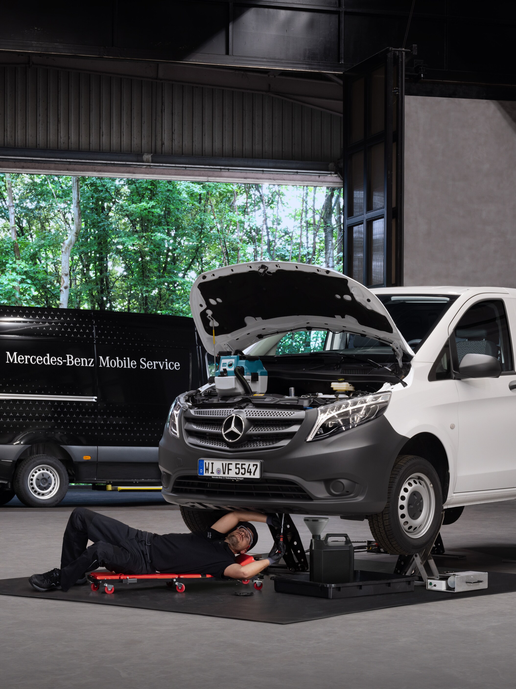 Um técnico repara um veículo ligeiro comercial Mercedes-Benz Vito branco.