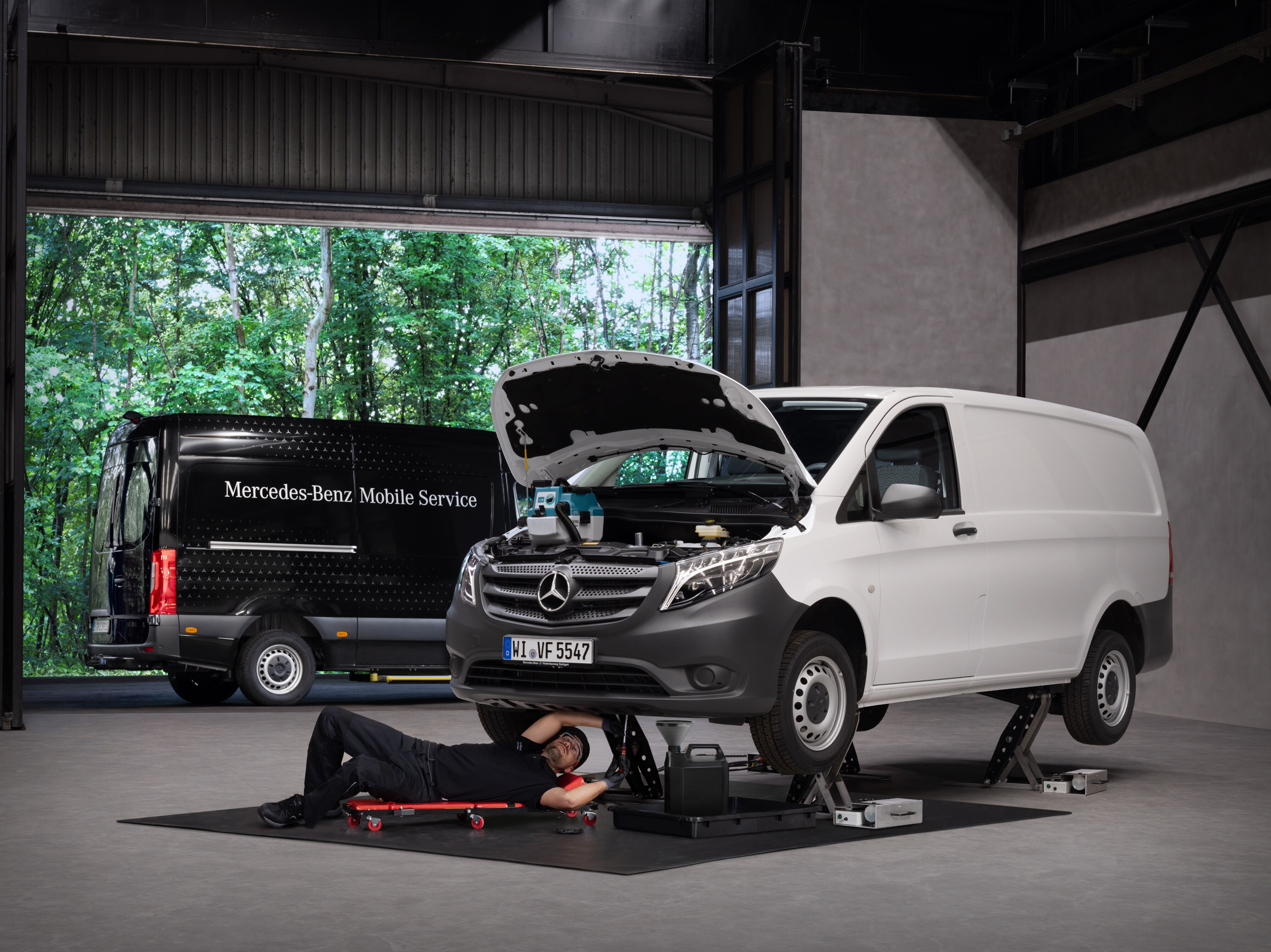Um técnico repara um veículo ligeiro comercial Mercedes-Benz Vito branco.