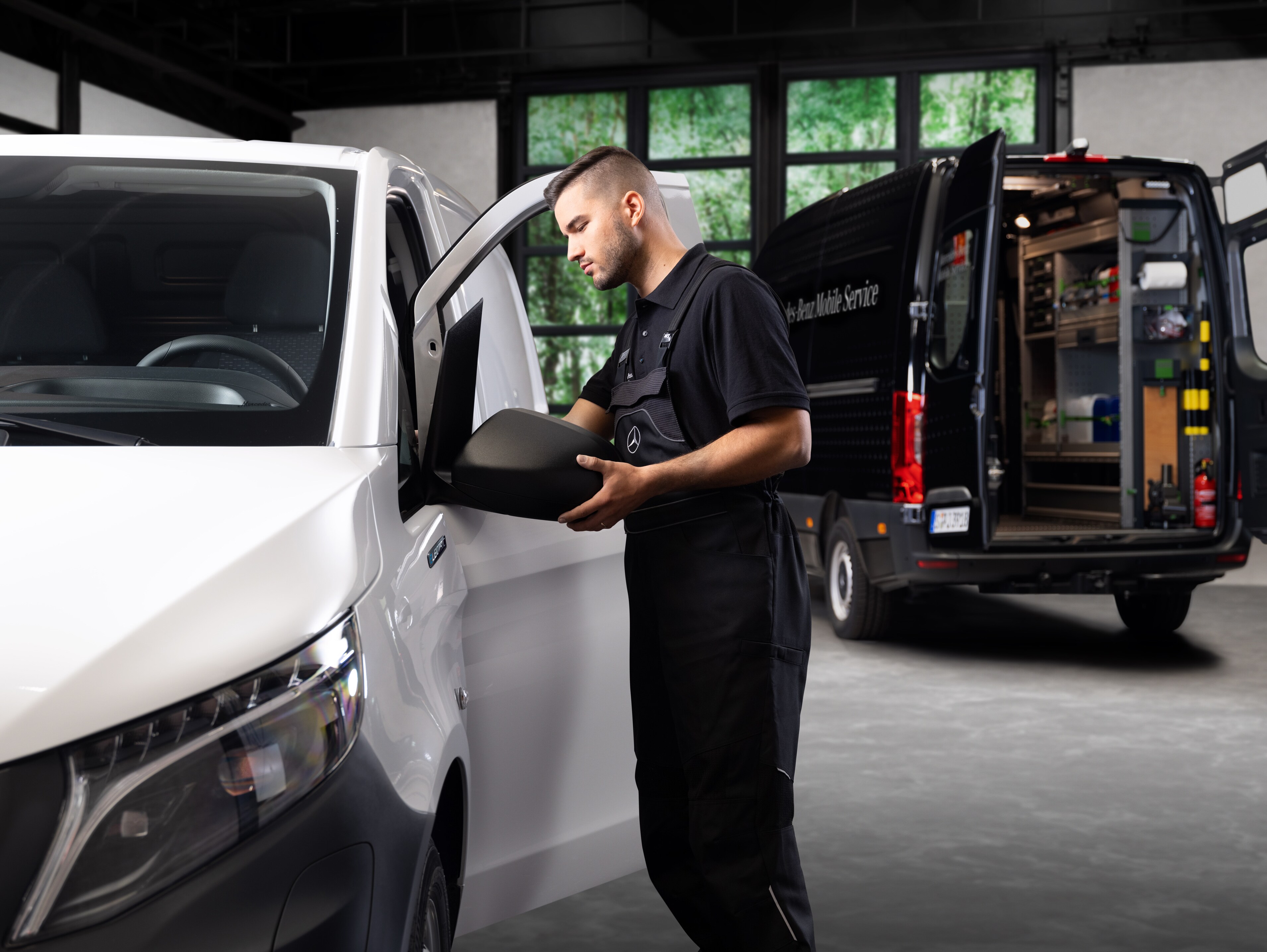 Um técnico substitui um espelho exterior de um veículo comercial ligeiro Mercedes-Benz Vito branco.