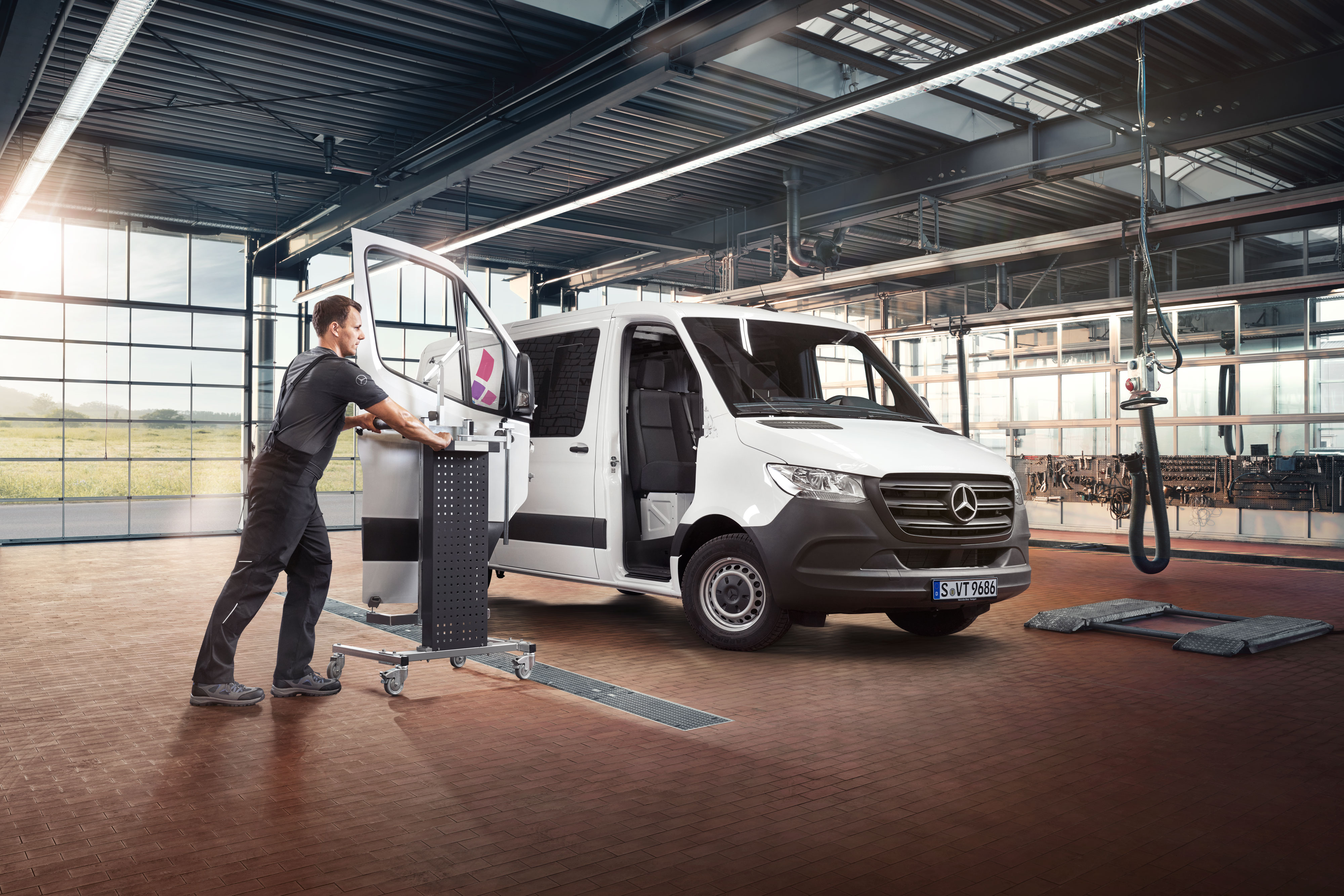 Mercedes-Benz | Reparação Mecânico a montar a porta de um Mercedes-Benz Sprinter branco.