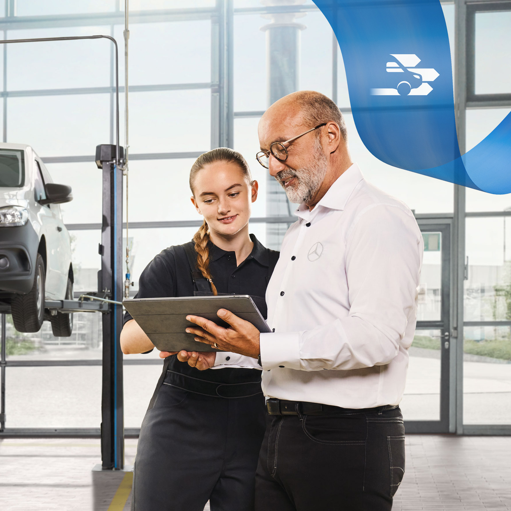 Mercedes-Benz | Manutenção Dois funcionários discutem o serviço de veículos comerciais ligeiros num veículos comerciais ligeiros Mercedes-Benz levantado na oficina.