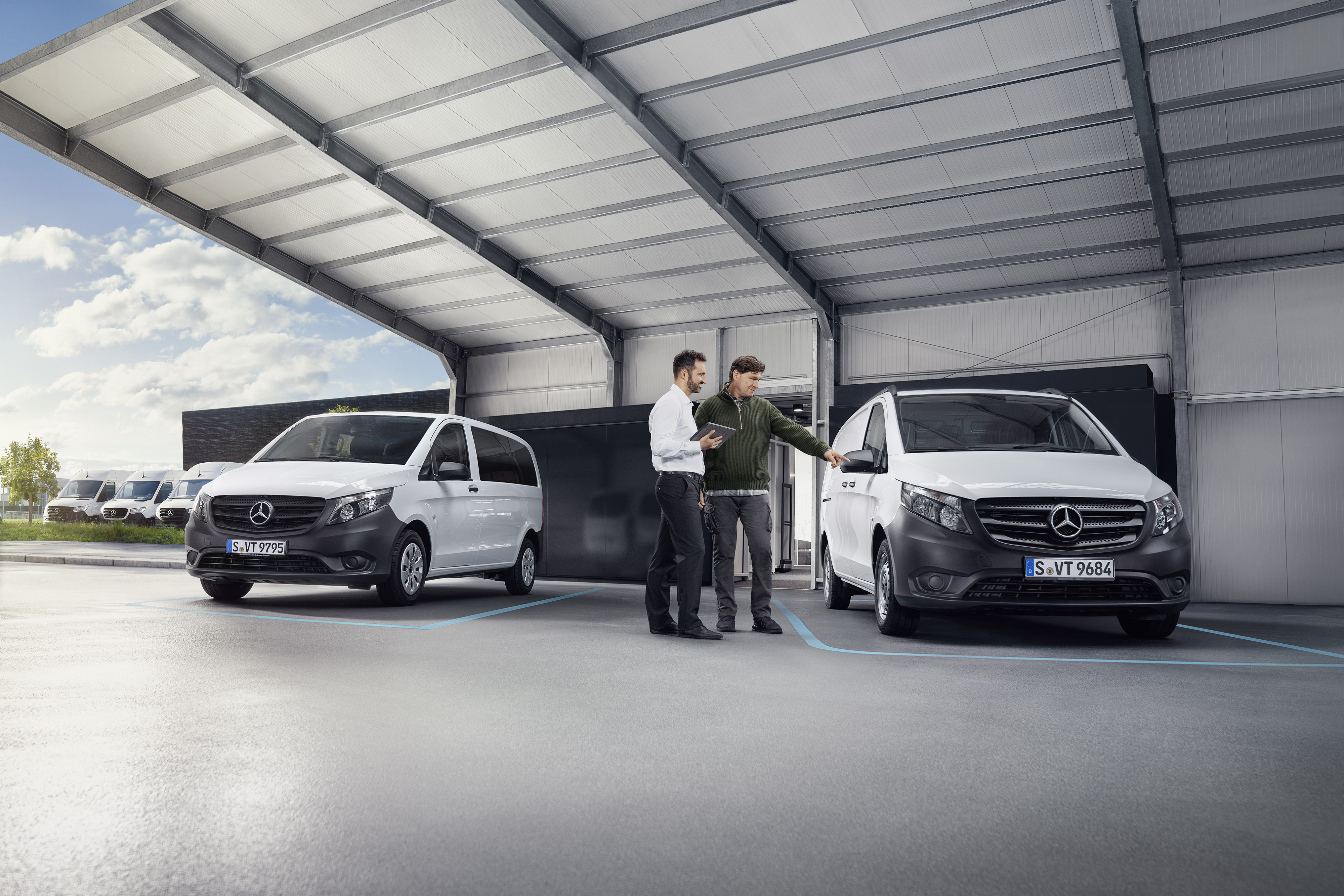 Mercedes-Benz | Recolha Agente do atendimento ao cliente da Mercedes-Benz com cliente nas instalações de uma oficina autorizada em frente a um veículo comercial ligeiro.