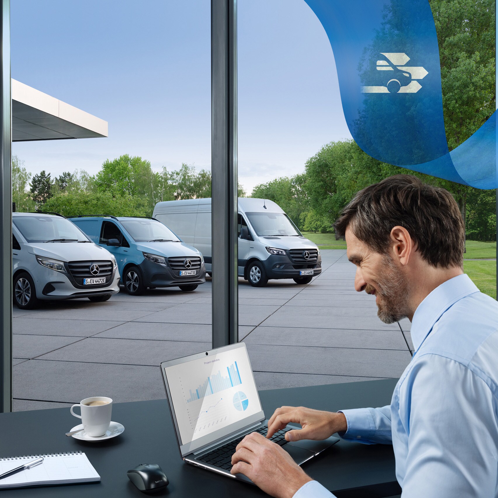 Um homem está a utilizar um computador portátil num escritório com uma série de veículos comerciais ligeiros Mercedes-Benz em segundo plano.
