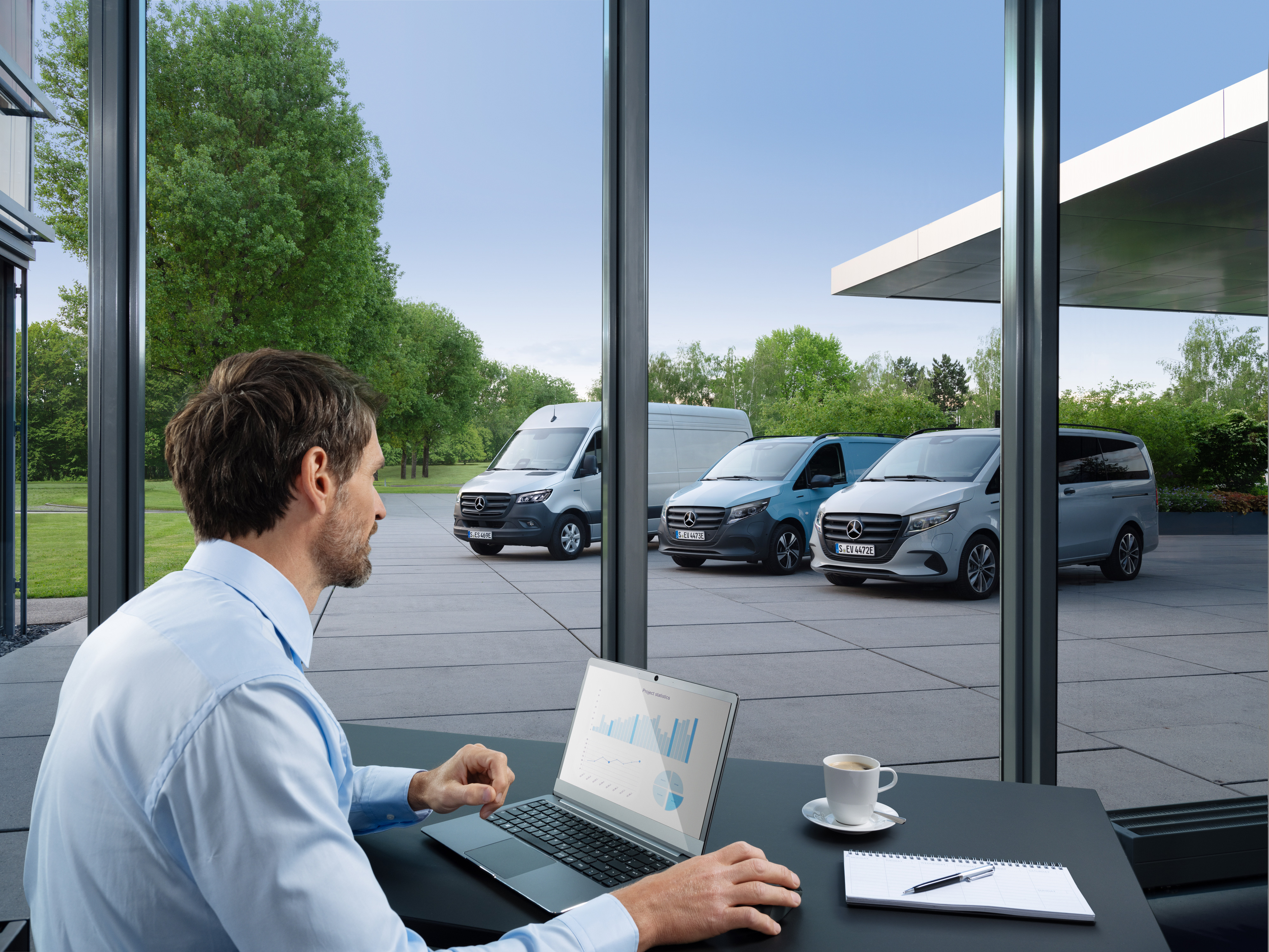 Mercedes-Benz | Tecnologia de veículos comerciais ligeiros | Van Uptime Monitor Homem a monitorizar vários veículos comerciais ligeiros Mercedes-Benz estacionados com um portátil, símbolo da gestão digital de frotas.