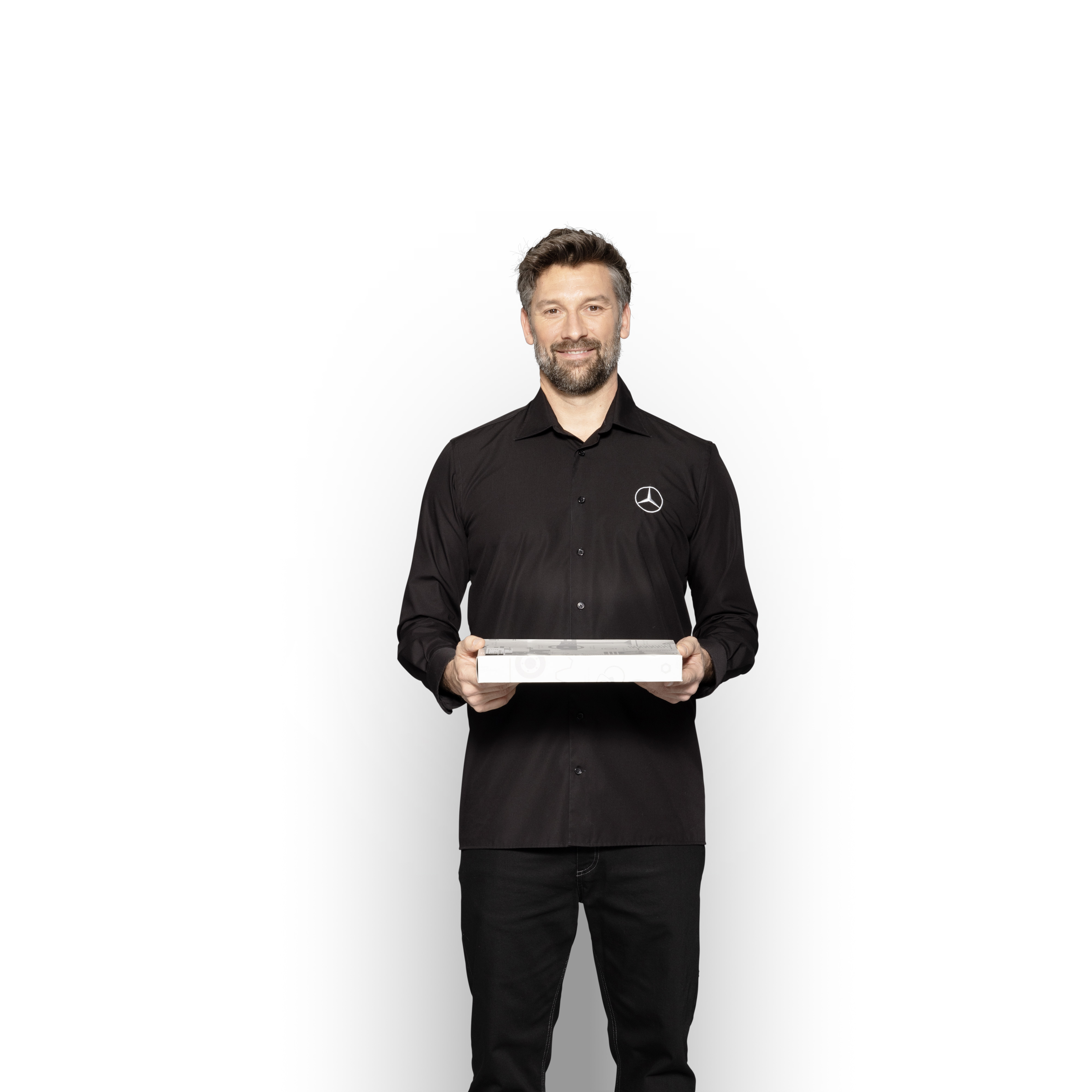 Mercedes-Benz | Carrinhas Peças Genuínas de Qualidade Técnico interno da Mercedes-Benz com uma caixa nas mãos para mostrar Peças Originais Mercedes-Benz.