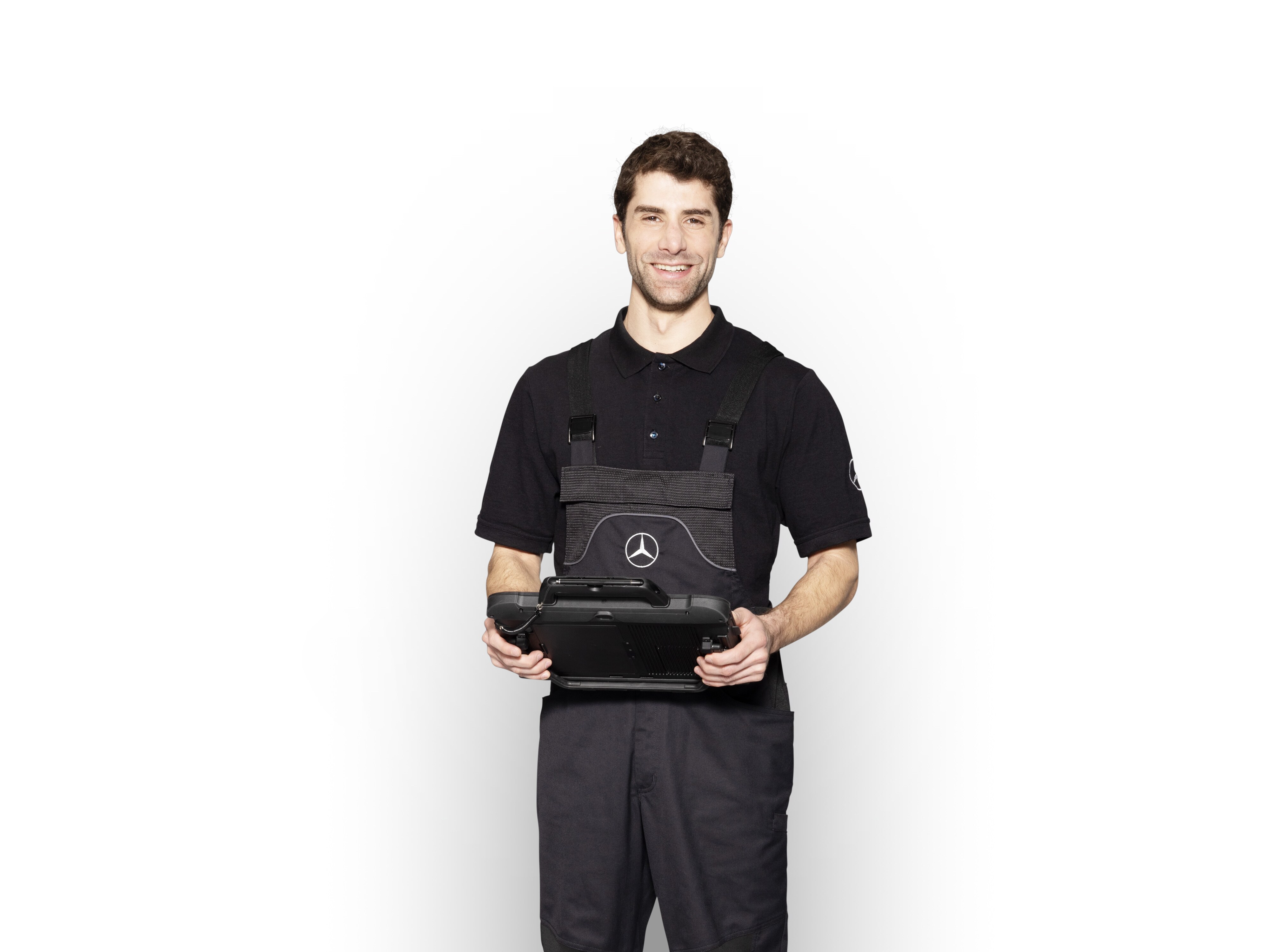 Mecânico interno da Mercedes-Benz com roupa de trabalho, a segurar um tablet pronto para comunicar os danos.