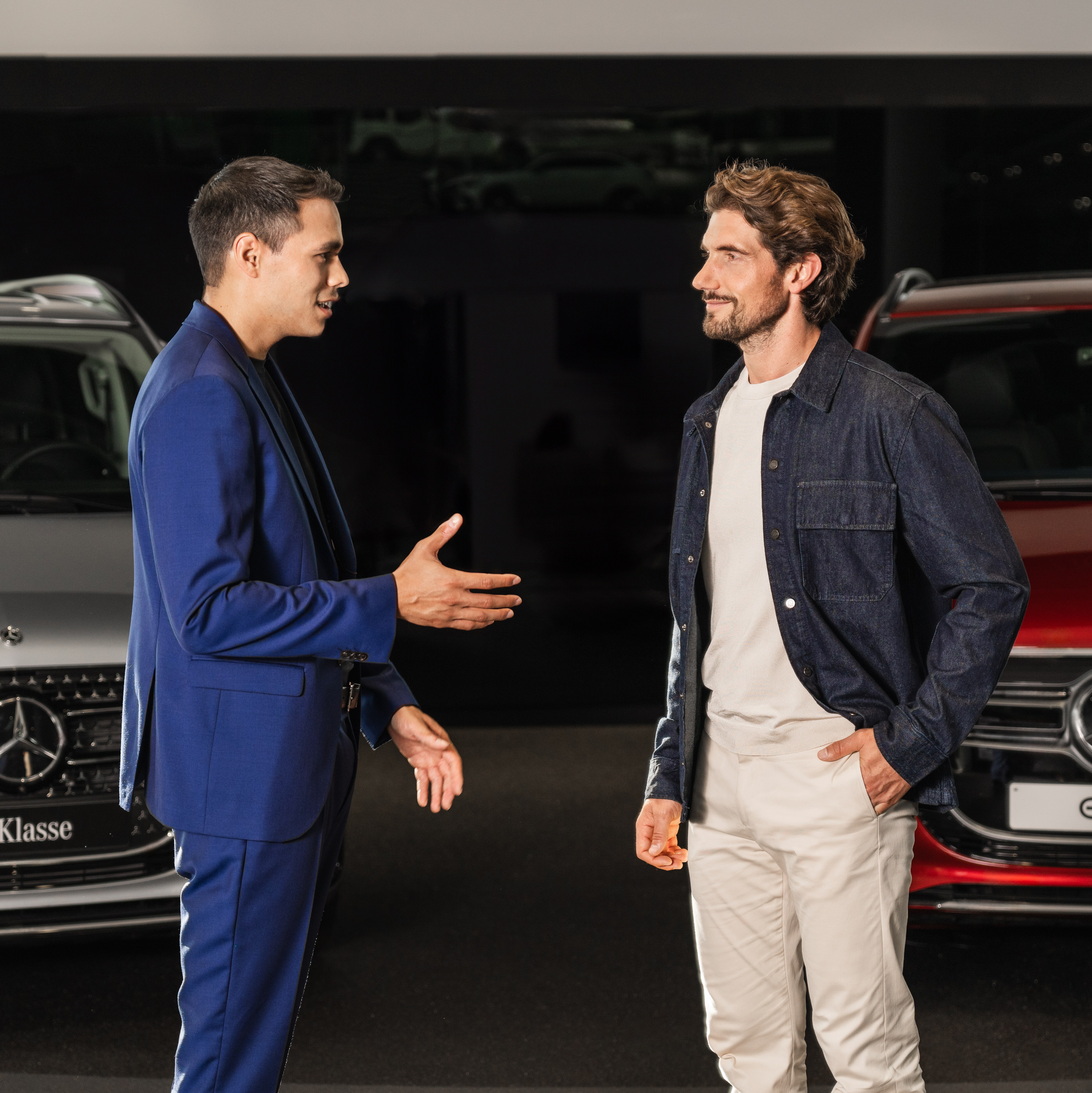 Um homem e uma mulher ao lado de um veículo comercial ligeiro Mercedes-Benz EQV preto