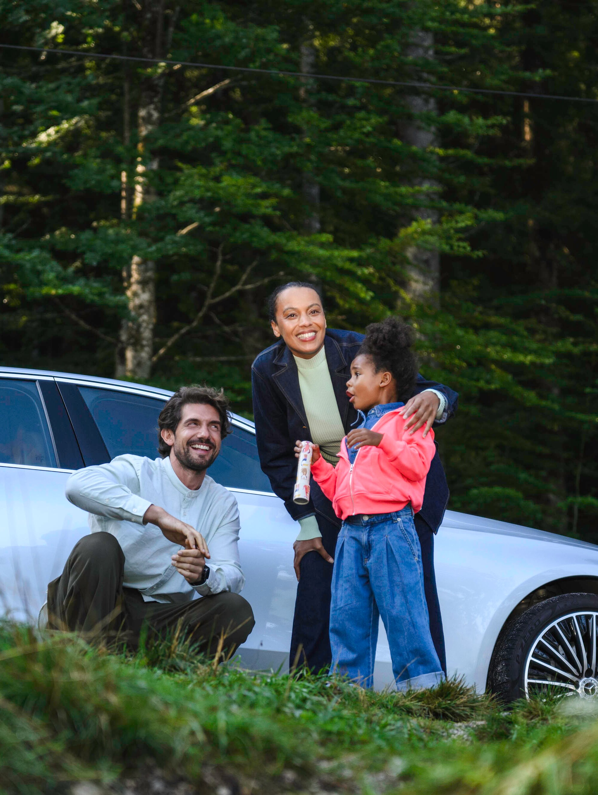 Um casal com uma criança numa Floresta junto a um Mercedes-Benz.