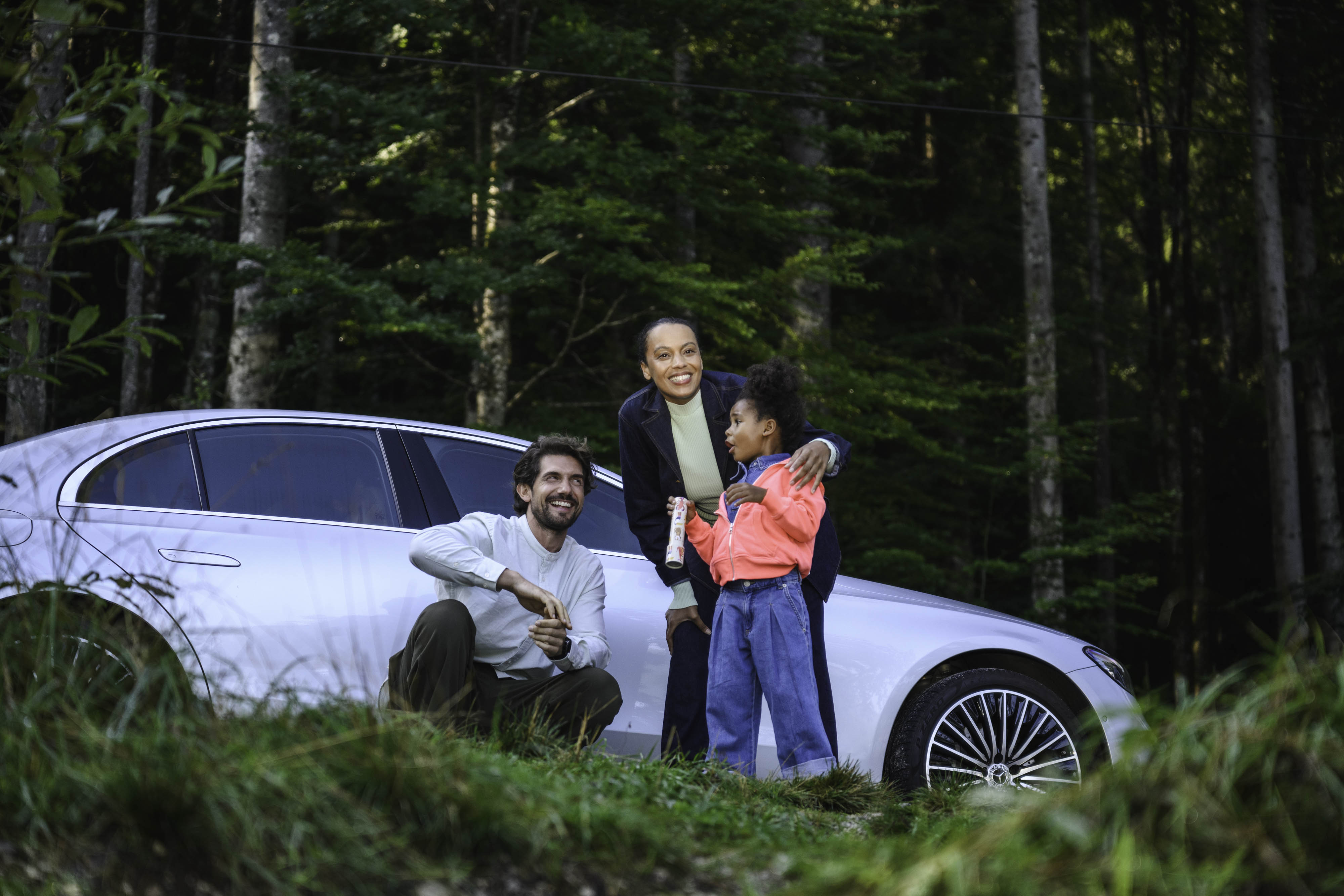 O Seguro para o seu Mercedes-Benz. Um casal com uma criança numa Floresta junto a um Mercedes-Benz.
