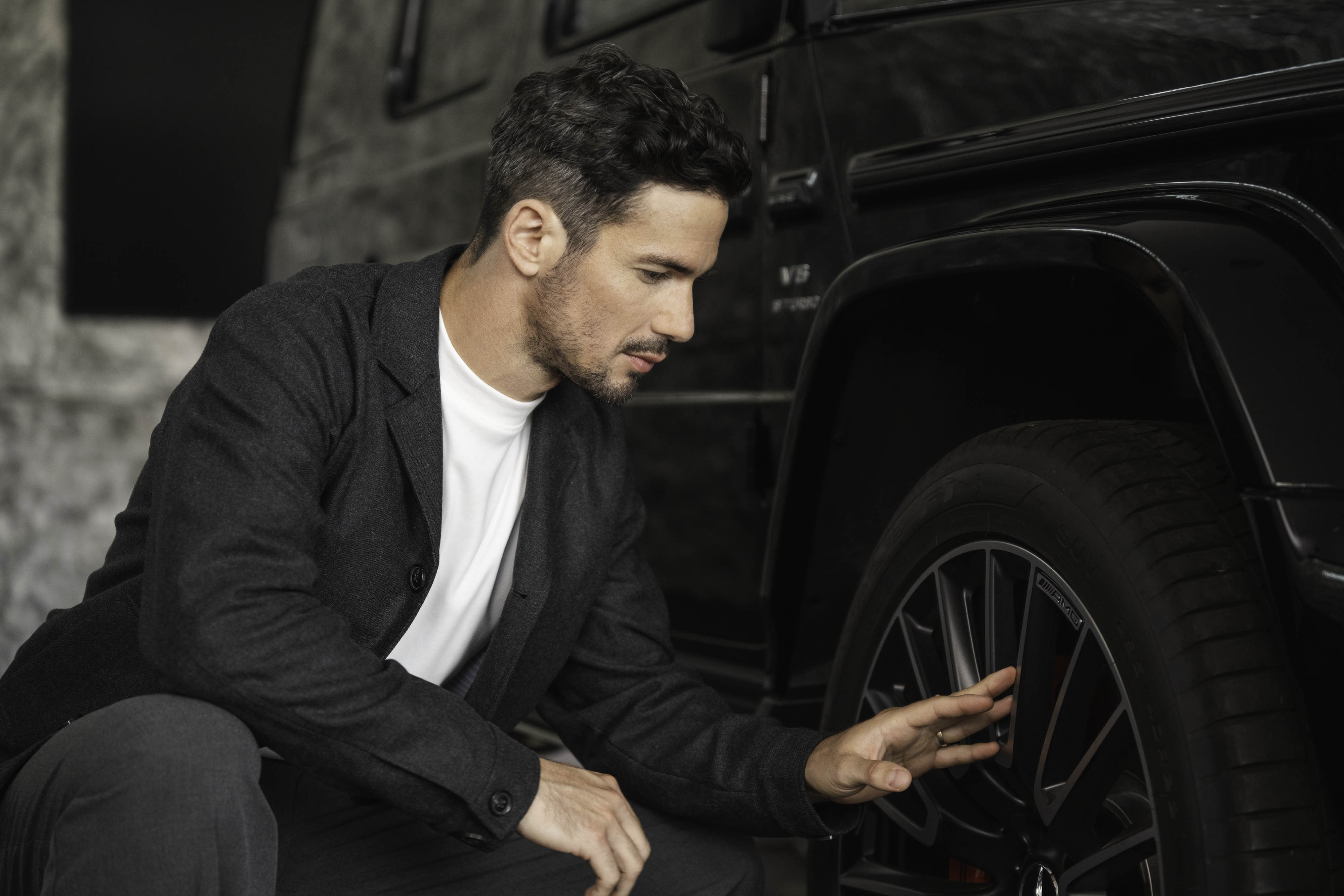 Campanhas de financiamento e mobilidade. Uma pessoa agachada a mexer na roda de um Mercedes-Benz.