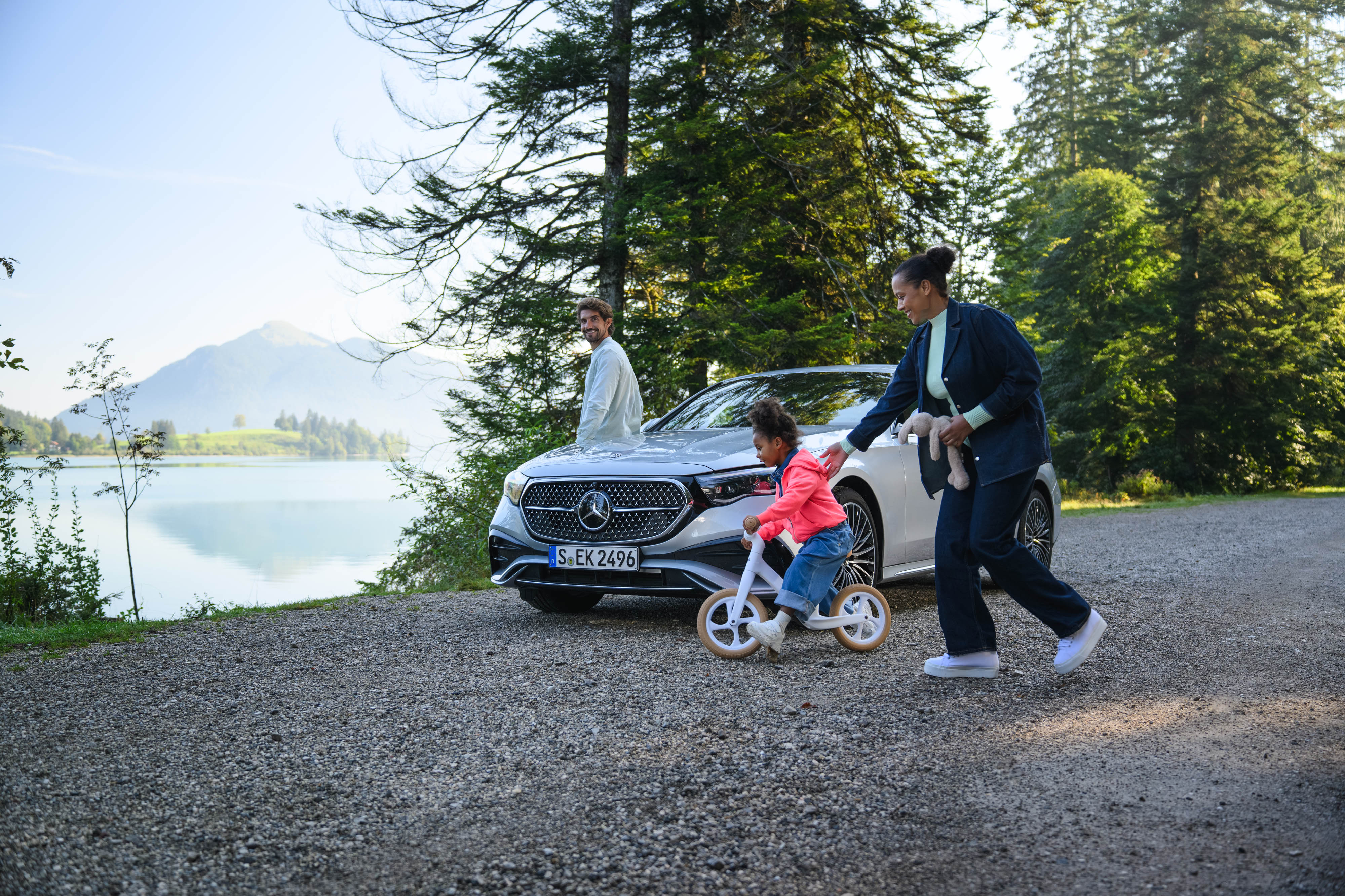Seguros Mercedes-Benz Duas pessoas a andar e uma criança criança de Bicicleta, junto a um Mercedes-Benz