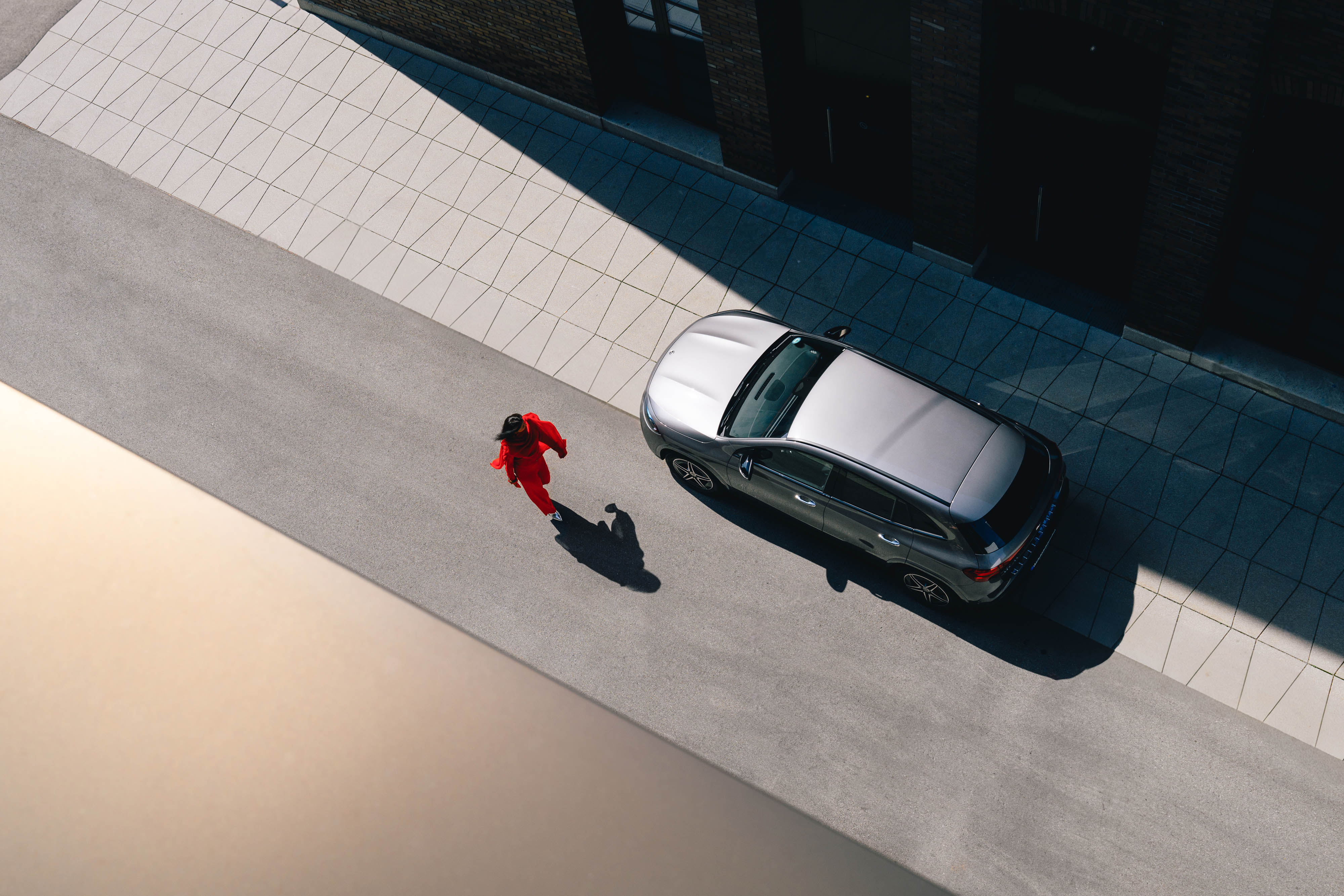 Campanhas Mercedes-Benz. Uma pessoa vista de cima a caminhar junto a um Mercedes-Benz.
